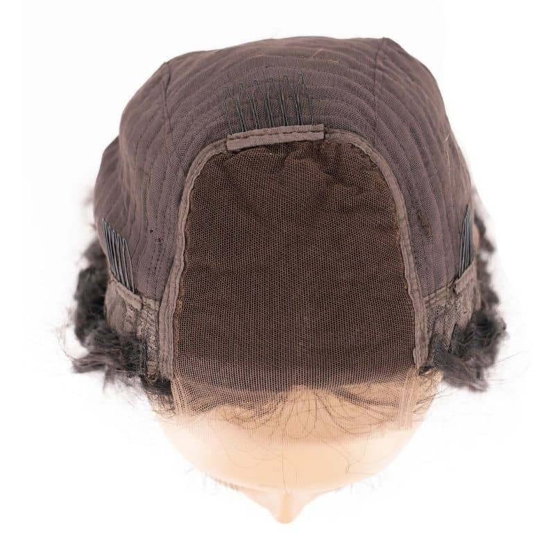 The image displays a detailed view of the wig cap for the Messy Curl Transparent Closure Wig by hairdiamondz, showcasing its transparent lace front. Made from mesh and fabric materials, it is presented on a mannequin head with the lace extending across the front edge to create a natural hairline appearance.