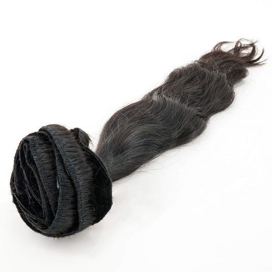 A set of Indian Wavy Natural Black Clip-In Extensions by hairdiamondz, coiled up at one end, displayed on a simple white background.
