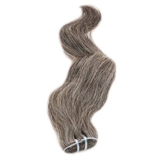 A bundle of hairdiamondz's Vietnamese Natural Gray Hair Extensions, showcasing 100% natural alternating gray and darker shades, is elegantly bound with blue ties against a white backdrop. This double drawn collection highlights a soft, flowing texture with a wavy, salt-and-pepper sophistication.